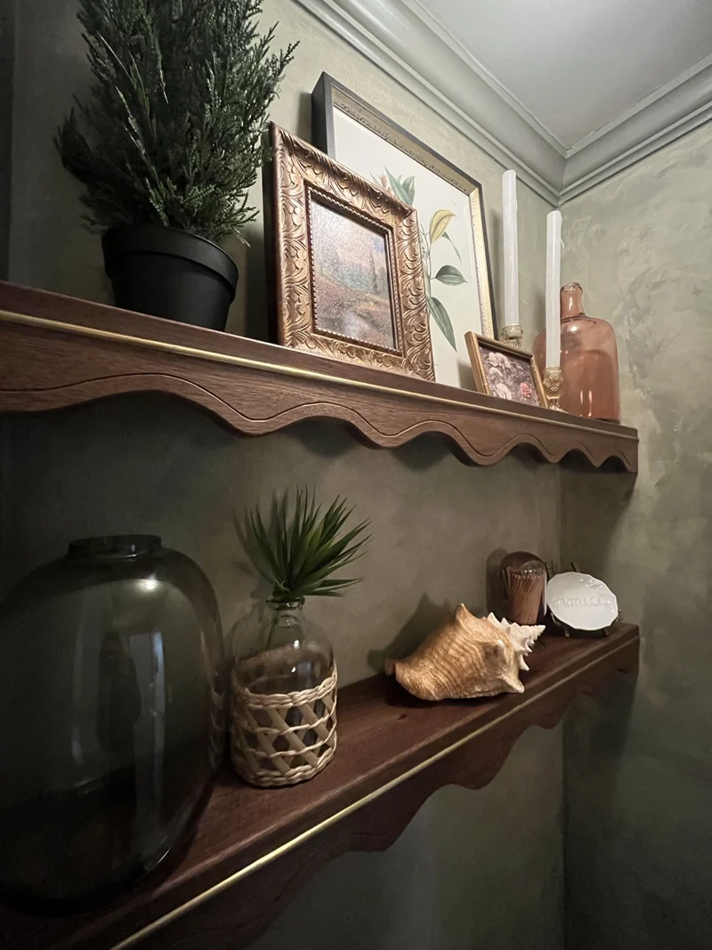 Books and collected objects on a scalloped shelf.